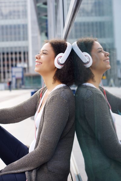 Portrait of a smiling african american girl enjoying music on headphones